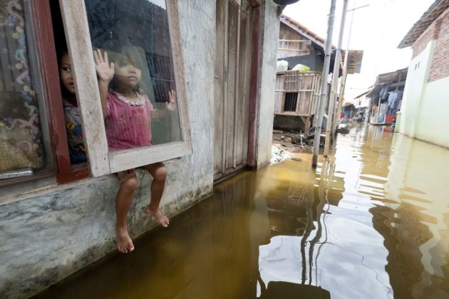 Alain Schroeder, Belgium. Winner, Best Single Image in Planet Earth – Landscape, Climate & Water Portfolio
Location: Jeruksari near Pekalongan, Indonesia
“Mutiari, 4 years old, plays with a friend in the flooded streets of Jeruksari. The sea level in Indonesia has risen by an alarming 4mm annually since 1992, a tangible consequence of climate change. Northern coastal cities are the most rapidly and severely affected, compounded by tidal flooding that inundates villages with slow-receding water. Poorly planned urbanization and infrastructure development also contribute to flooding in these low-lying areas.”