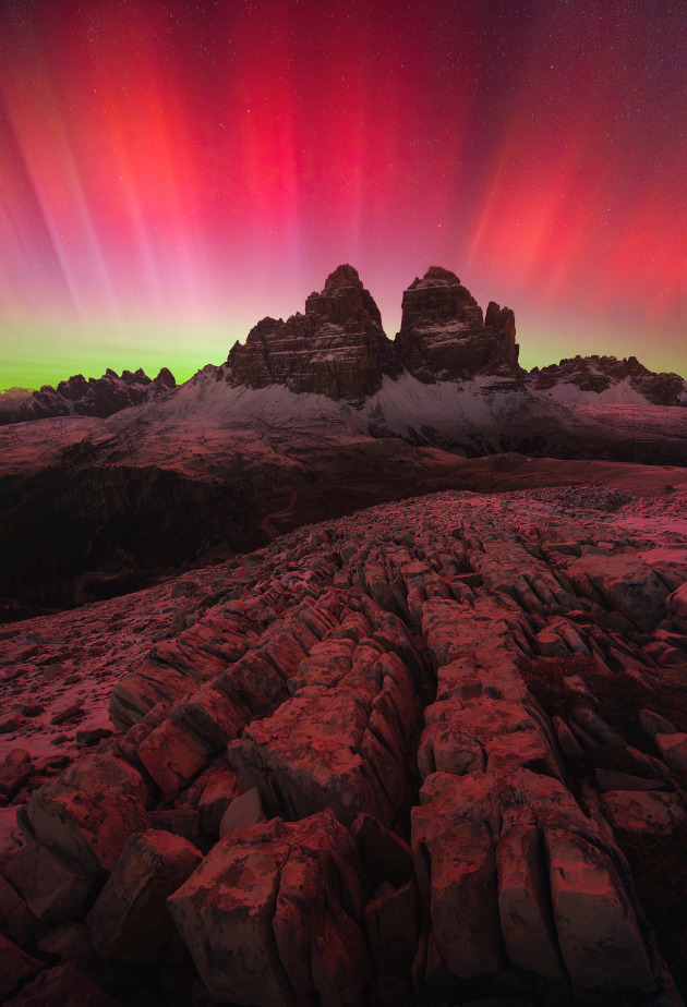 “Coronation” – Roksolyana Hilevych, Dolomites, Italy.
That day, after a storm of mixed snow and rain, the sky fortunately cleared after 8 p.m. (about an hour after sunset). As I walked to my location, I could already see red hues peeking through the clouds. The adrenaline and excitement were so overwhelming that I hardly noticed the cold and strong wind, which never let up during the night at 2,450 meters above sea level.
I ended up taking 840 photos from 8:30 p.m. to 5 a.m., hoping to capture the perfect moment. This photo was taken around 1:30 a.m., during the second peak of the aurora, the strongest ever, which lasted only a few seconds.