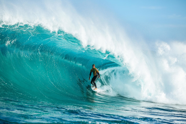John John Florence standing in a big blue barrel front lit during the 2019 Margaret River Pro in Western Australia. Canon 5D Mark IV, EF70-200mm f/2.8L USM lens @ 145mm. 1/2000s @ f4, ISO 200.