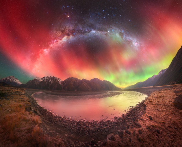 “Sky Fire” – Tom Rae, Aoraki/Mt. Cook National Park, New Zealand.
The Milky Way arches over the dramatic landscape of Aoraki Mount Cook National Park, captured during a rare G5 geomagnetic storm in May 2024. This aurora display was one of the most breathtaking sights I’ve ever witnessed—a magical evening watching the lights dance across the crystal-clear sky. The excitement was shared by everyone under the stars, as this aurora was potentially the strongest in a century.